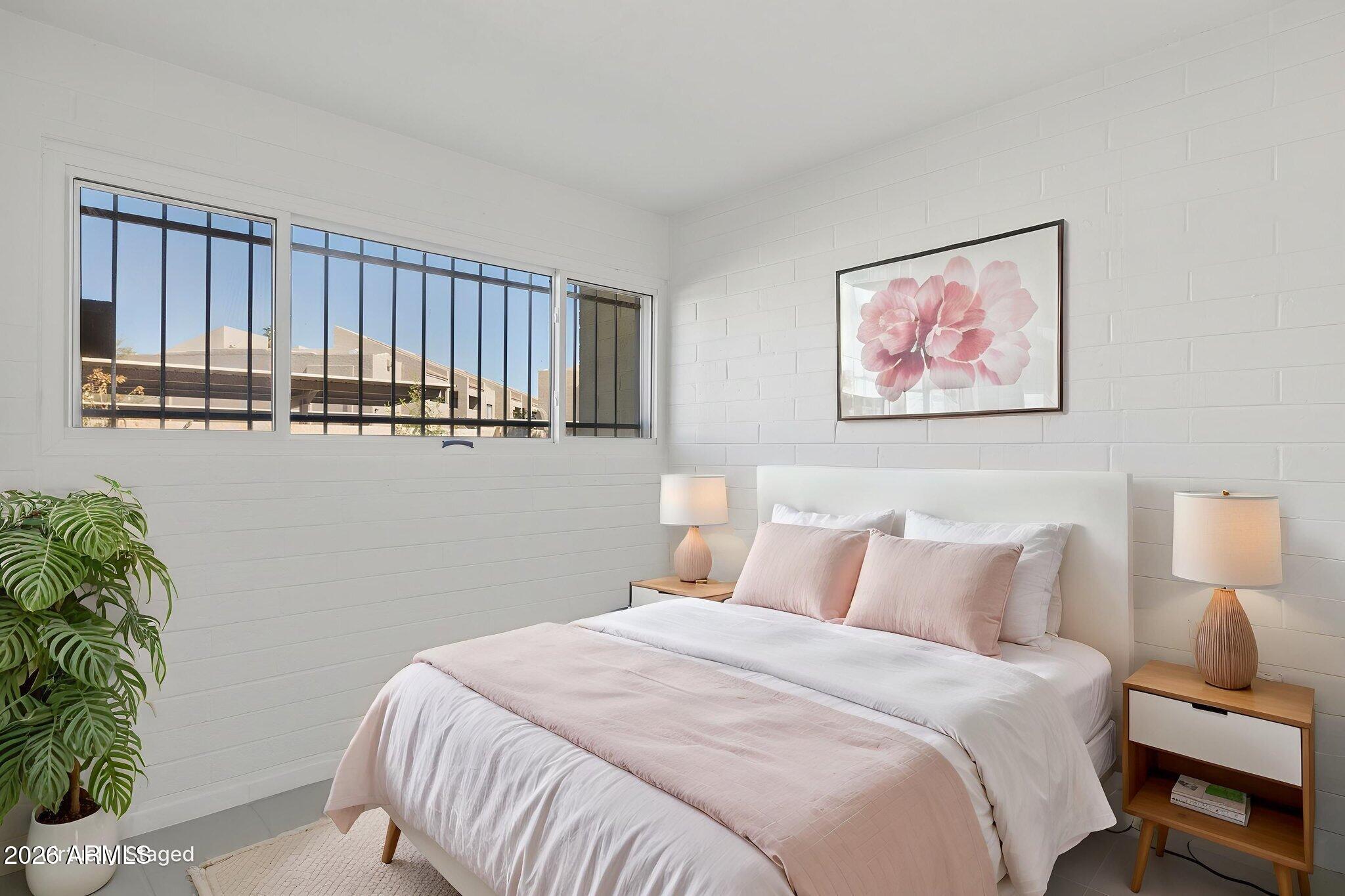 825 North Hayden Road, Unit C104 Scottsdale, AZ 85257 - Photo 12 of 33 a bedroom with a bed and a painting on the wall