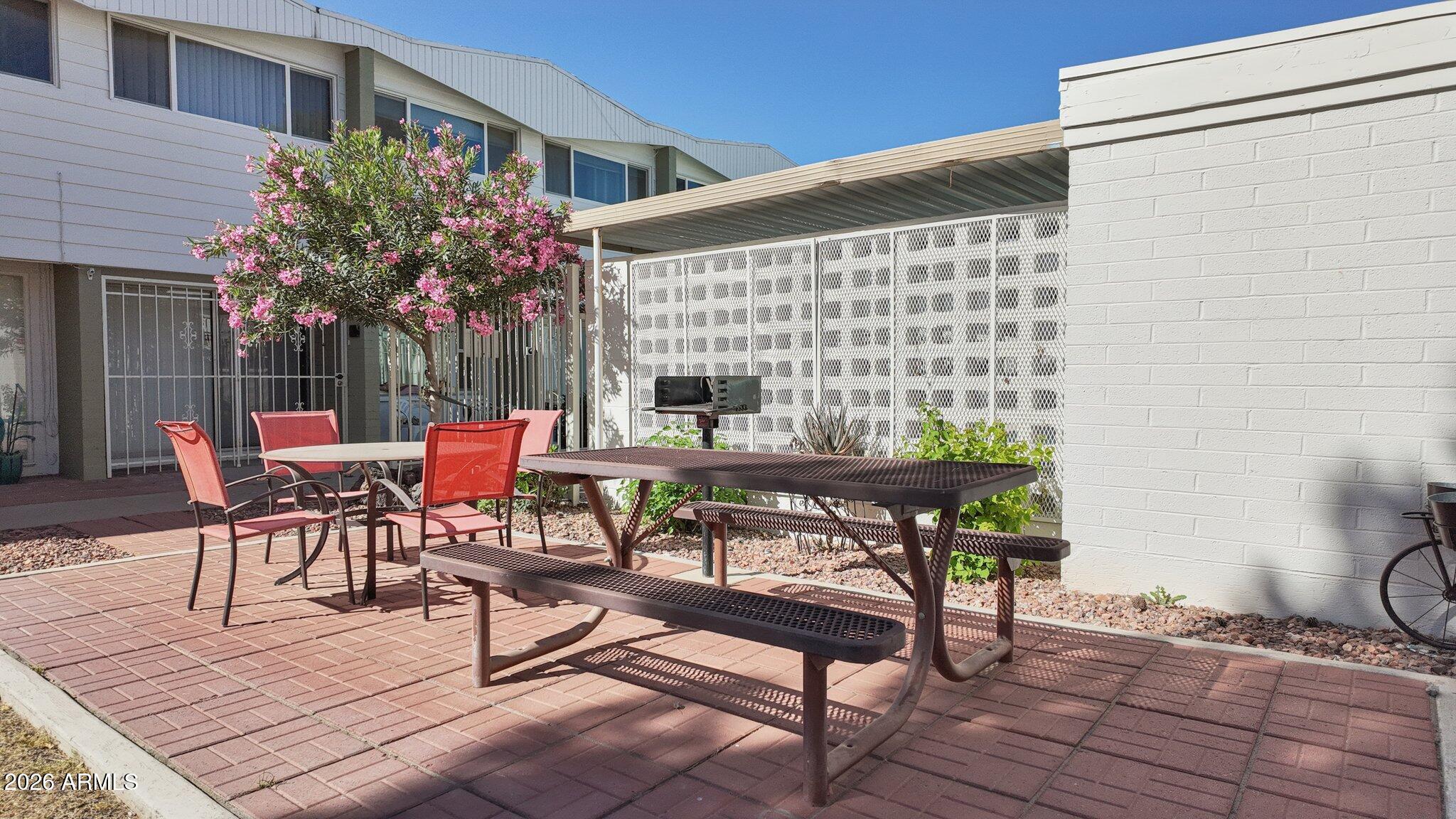 825 North Hayden Road, Unit C104 Scottsdale, AZ 85257 - Photo 26 of 33 a backyard of a house with table and chairs
