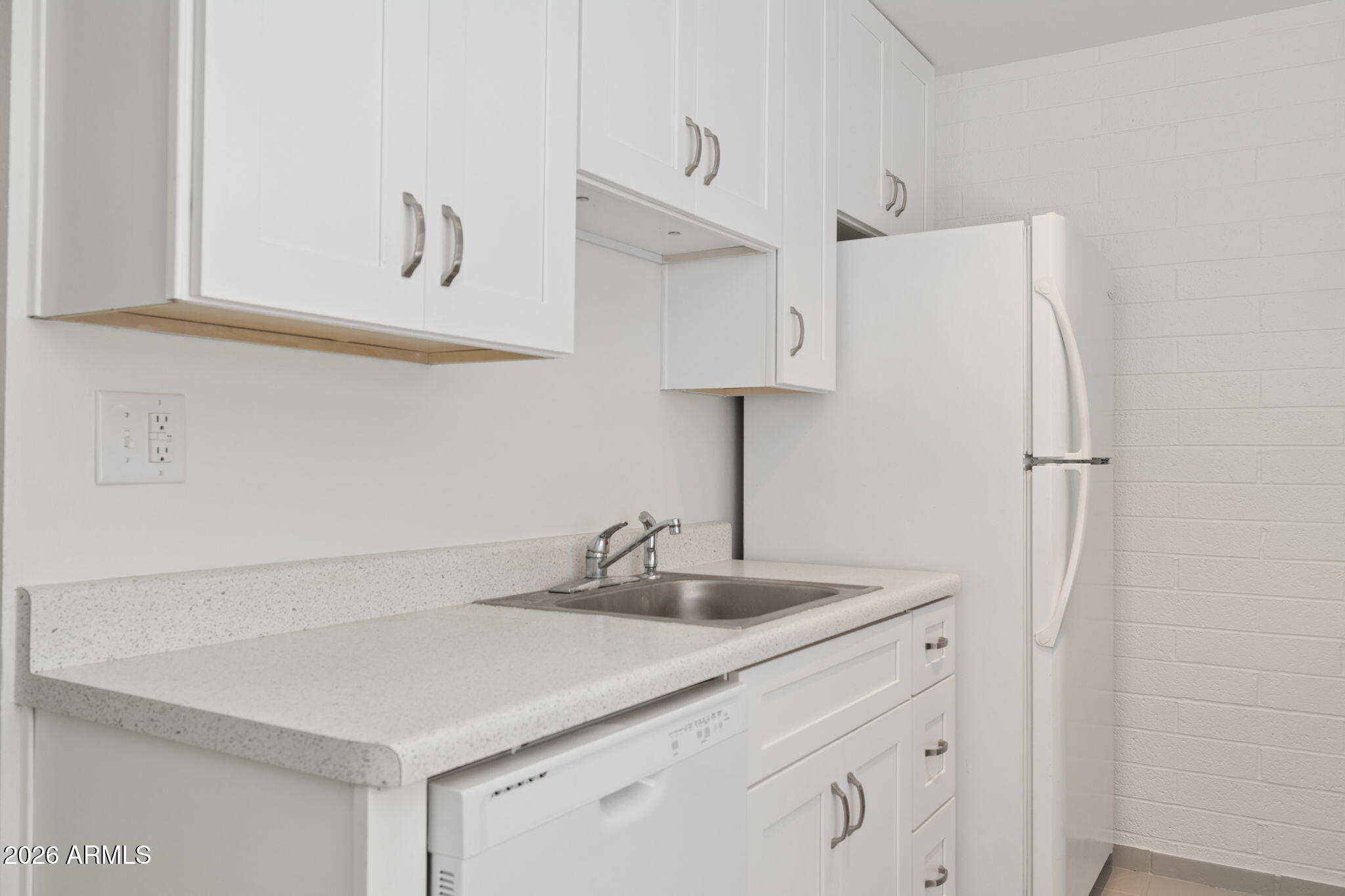 825 North Hayden Road, Unit C104 Scottsdale, AZ 85257 - Photo 7 of 33 a kitchen with stainless steel appliances a sink and a refrigerator