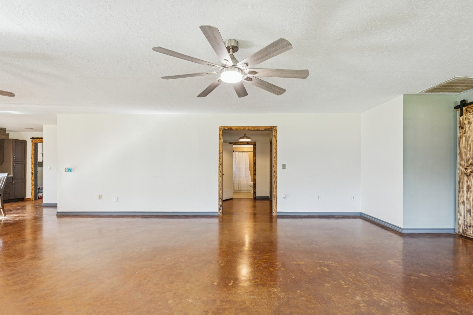 392 Robert E Lee Road Livingston, TX 77351 - Photo 15 of 43 an empty room with wooden floor chandelier fan and windows