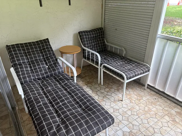 a view of a chairs and table in the back yard