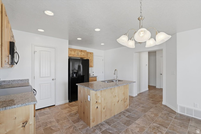 1218 Moonlight Drive Elk Ridge, UT 84651 - Photo 7 of 44 Kitchen with light wood finish cabinetry, stone finish floors, black appliances, an island with sink, and light stone countertops