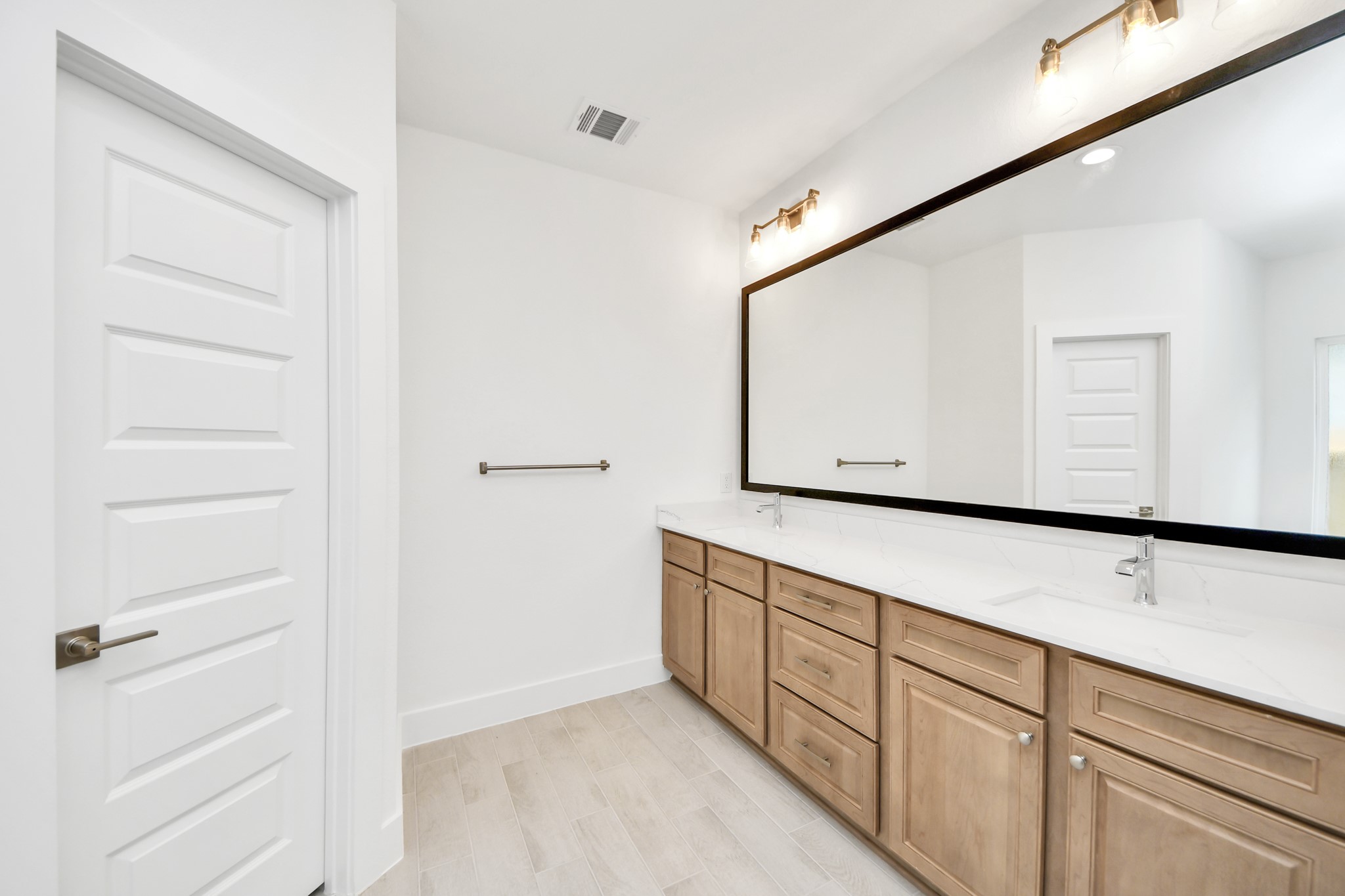 3102 Native Spg Drive Spring, TX 77373 - Photo 27 of 47 Elevate your daily routine at the elegant vanity, now equipped with double sinks, light countertops, modern hardware, and beautiful vanity lights.