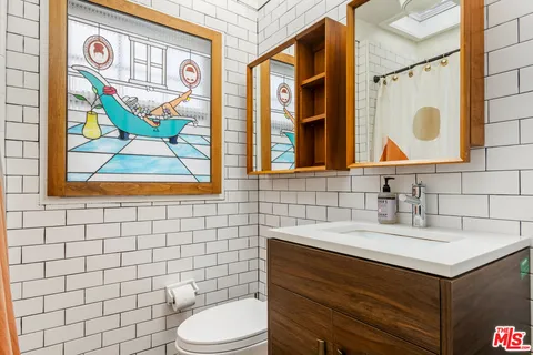 a bathroom with a sink vanity mirror and toilet