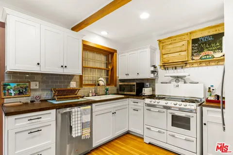 a kitchen with stainless steel appliances white cabinets and a stove top oven