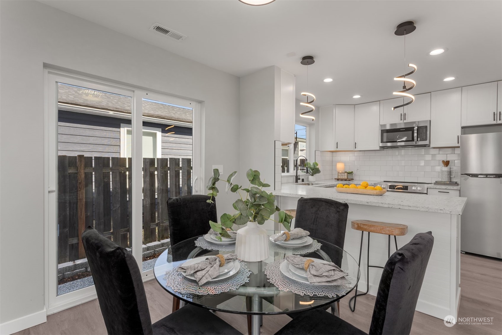 6633 South Pine Street Tacoma, WA 98409 - Photo 12 of 23 a view of a dining room with furniture a kitchen and chandelier
