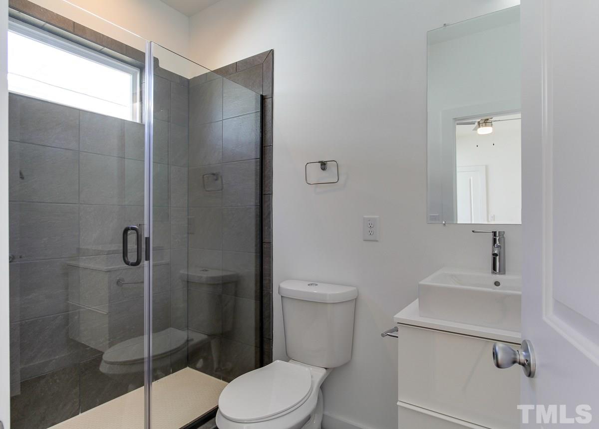 1310 South East Street Raleigh, NC 27601 - Photo 7 of 21 a bathroom with a toilet sink vanity and shower