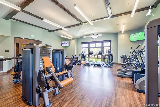 a view of a room with gym equipment and a wooden floor