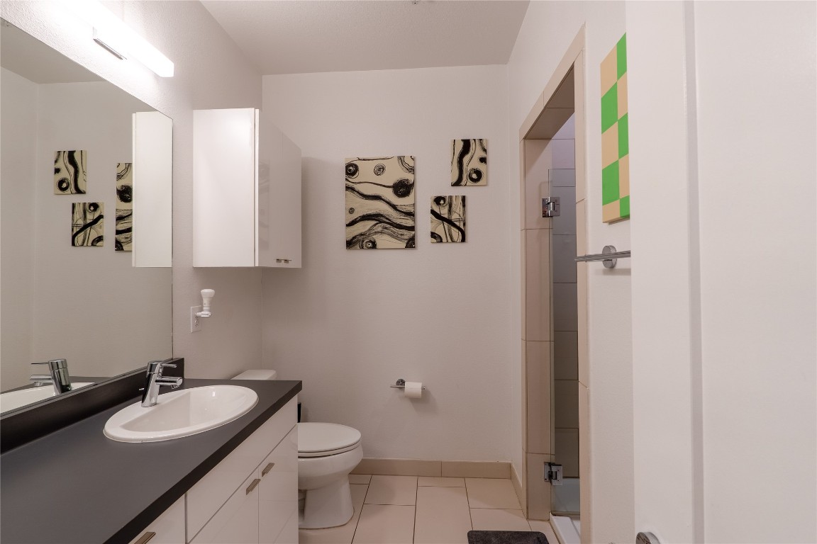 4361 South Congress Avenue, Unit 314 Austin, TX 78745 - Photo 12 of 25 a bathroom with a granite countertop sink and a mirror