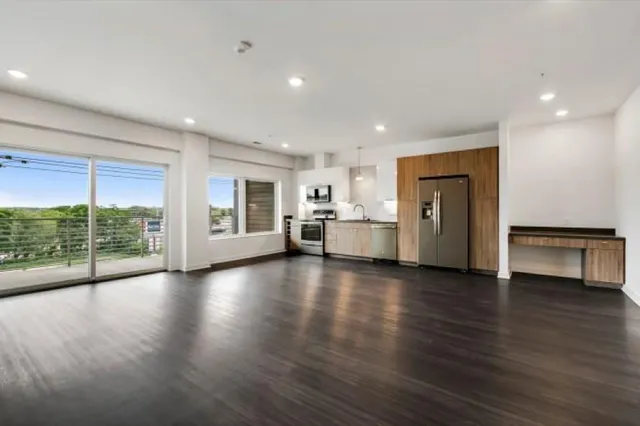 a view of empty room with wooden floor and windows
