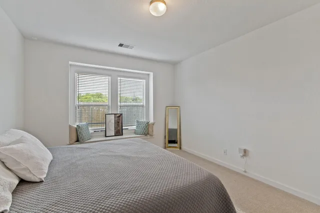 a spacious bedroom with a bed and a window