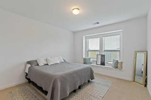 a spacious bedroom with a bed and glass door