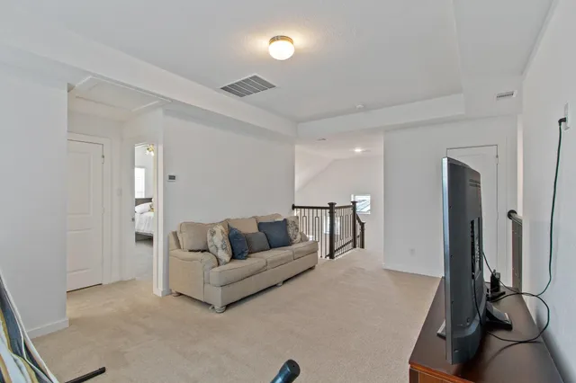 a living room with furniture and a gym machine