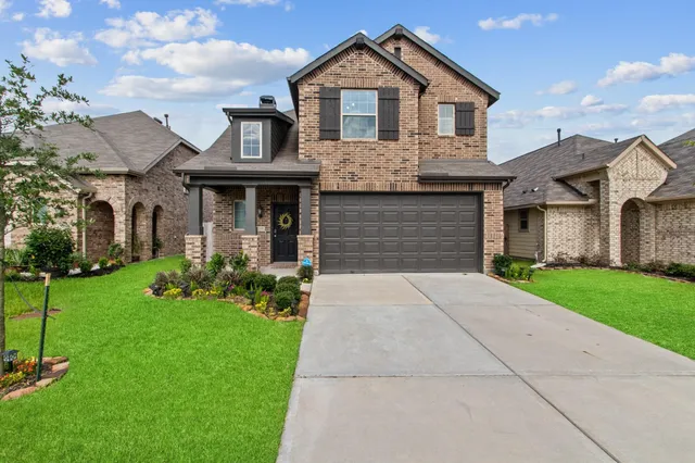 a front view of a house with a yard and garage