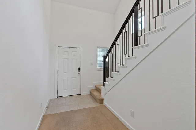 a view of staircase with wooden floor and white walls