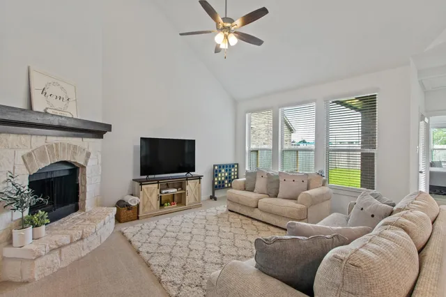 a living room with furniture a fireplace and a flat screen tv