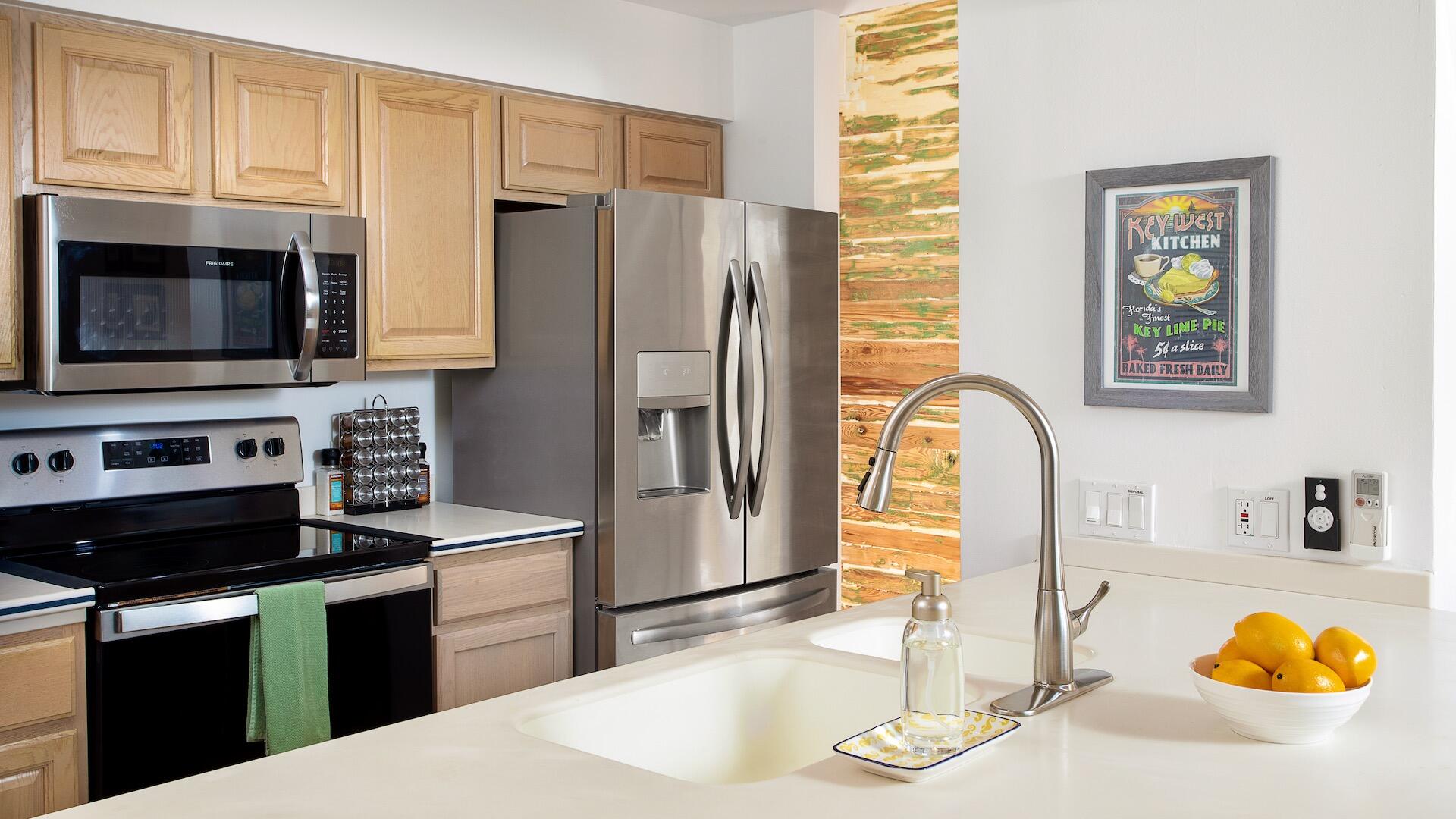 4 Aronovitz Lane Key West, FL 33040 - Photo 10 of 36 a kitchen with stainless steel appliances kitchen island granite countertop a refrigerator a stove top oven and a sink