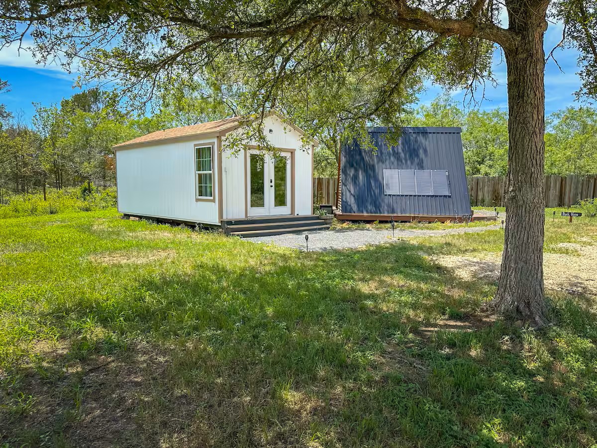 16107 Fagerquist Road Del Valle, TX 78617 - Photo 13 of 17 Two distinct structures stand amidst natural landscaping, offering flexible living options.