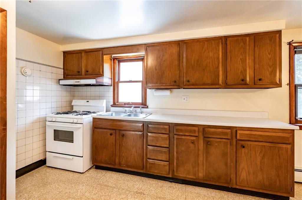 535 Neely Street Baden, PA 15005 - Photo 12 of 42 a kitchen with stainless steel appliances granite countertop a stove a sink and a microwave