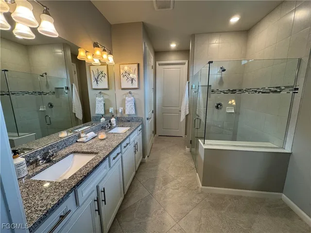 a bathroom with a granite countertop sink mirror and shower