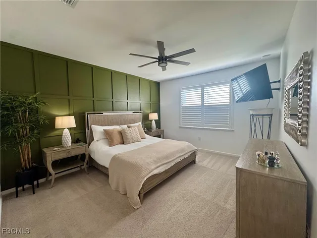 a spacious bedroom with a bed a chandelier and a window