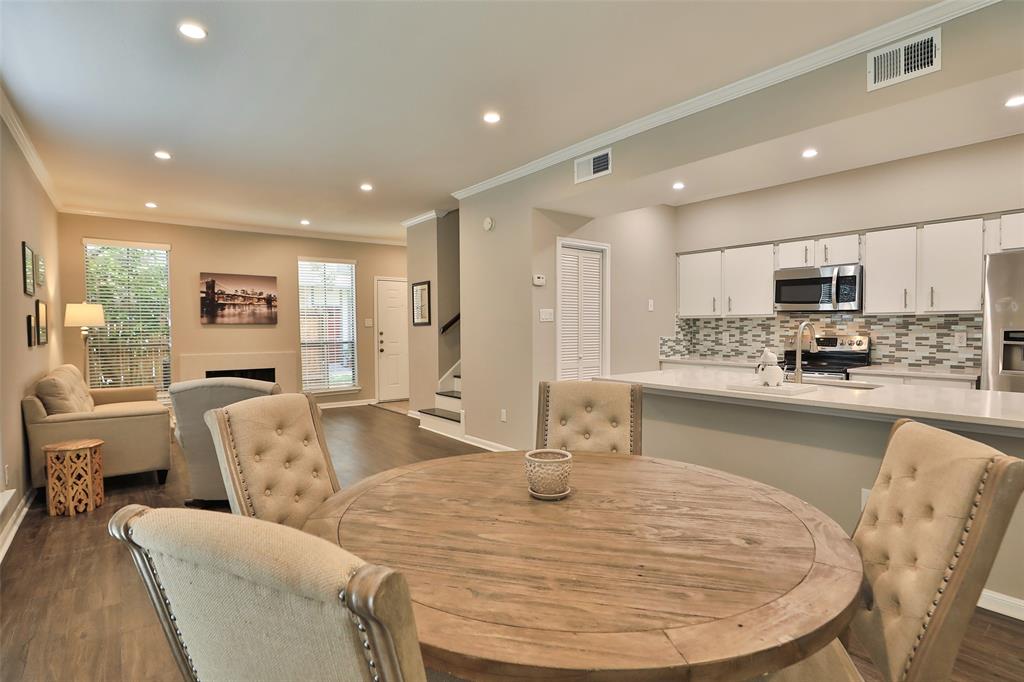 a room with stainless steel appliances kitchen island granite countertop a couch and white cabinets