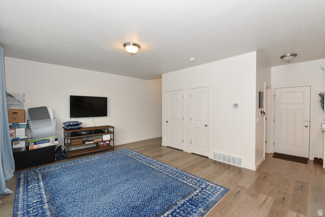 1632 North Apache Road Saratoga Springs, UT 84045 - Photo 10 of 28 Open-concept living space featuring light wood-finish flooring, white walls, and flush-mount ceiling lighting