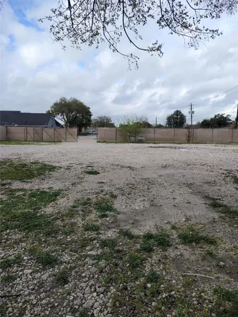 a view of dirt field with large trees