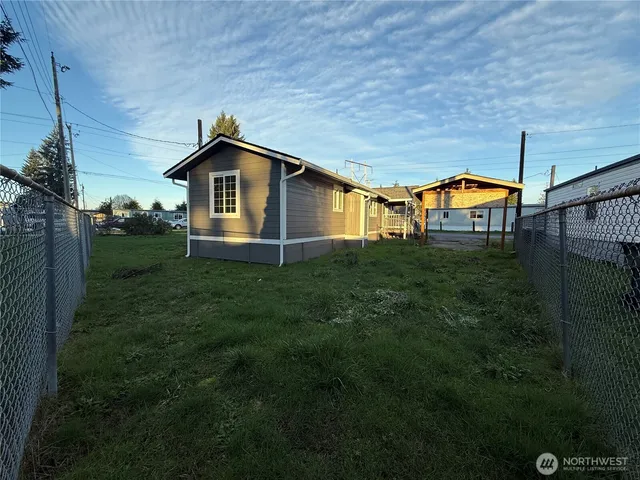 a backyard of a house with table and chairs