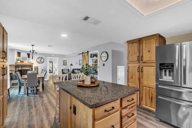 a kitchen with kitchen island granite countertop a sink stove and cabinets