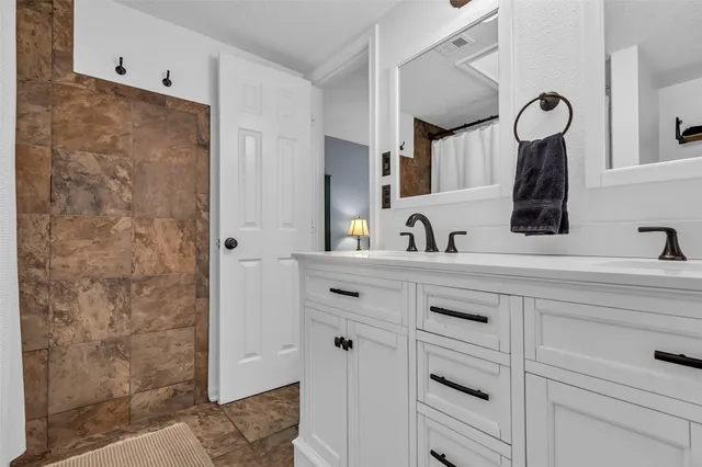 a bedroom with a large bed a chandelier and windows