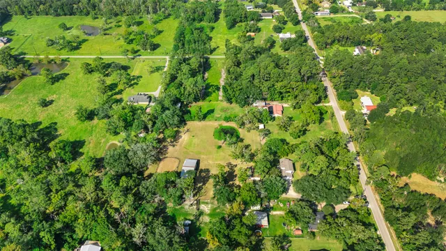 an aerial view of a residential houses with yard