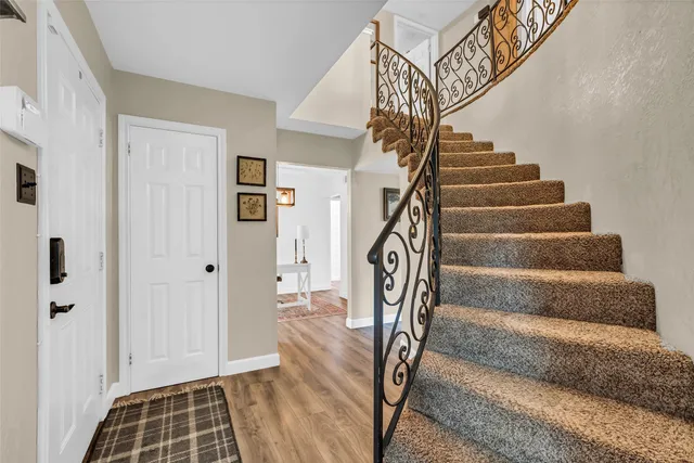 a view of staircase with white walls and railing