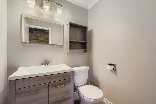 a bathroom with a toilet a sink and mirror