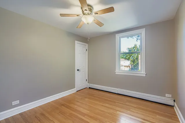 an empty room with a window and a ceiling fan