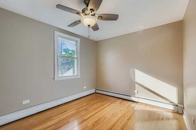 an empty room with a window and a ceiling fan