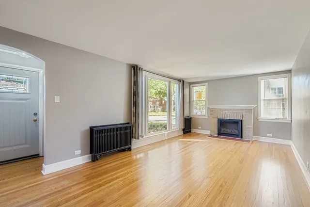 wooden floor fireplace and windows in an empty room