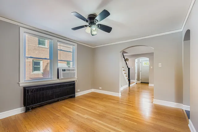 a view of an empty room with a window and wooden floor