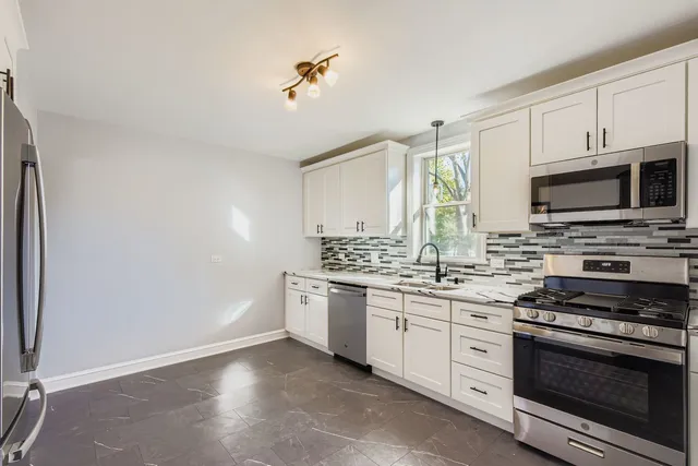 a kitchen with stainless steel appliances a stove microwave and sink