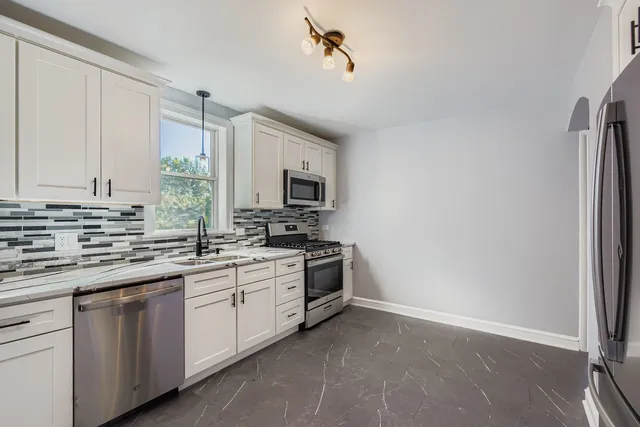 a kitchen with appliances a sink and cabinets