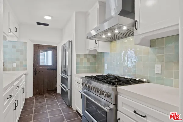 a kitchen with granite countertop a stove and a shower