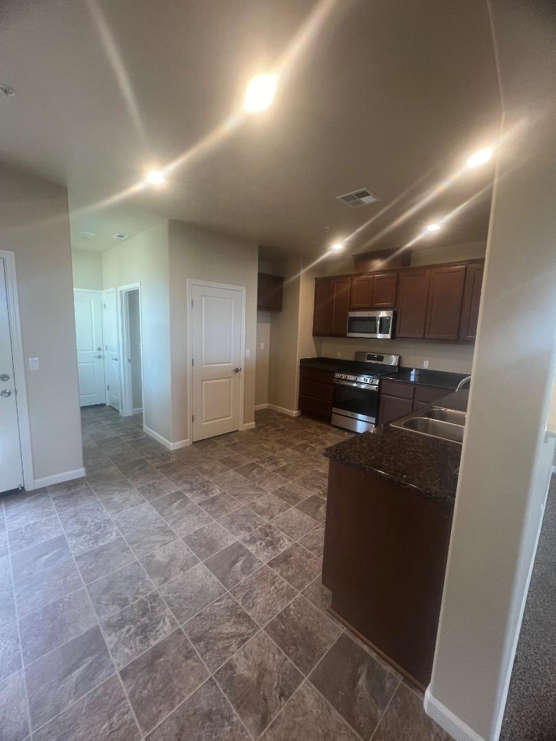 672 Bikle Drive King City, CA 93930 - Photo 28 of 39 a kitchen with kitchen island granite countertop a refrigerator and a sink