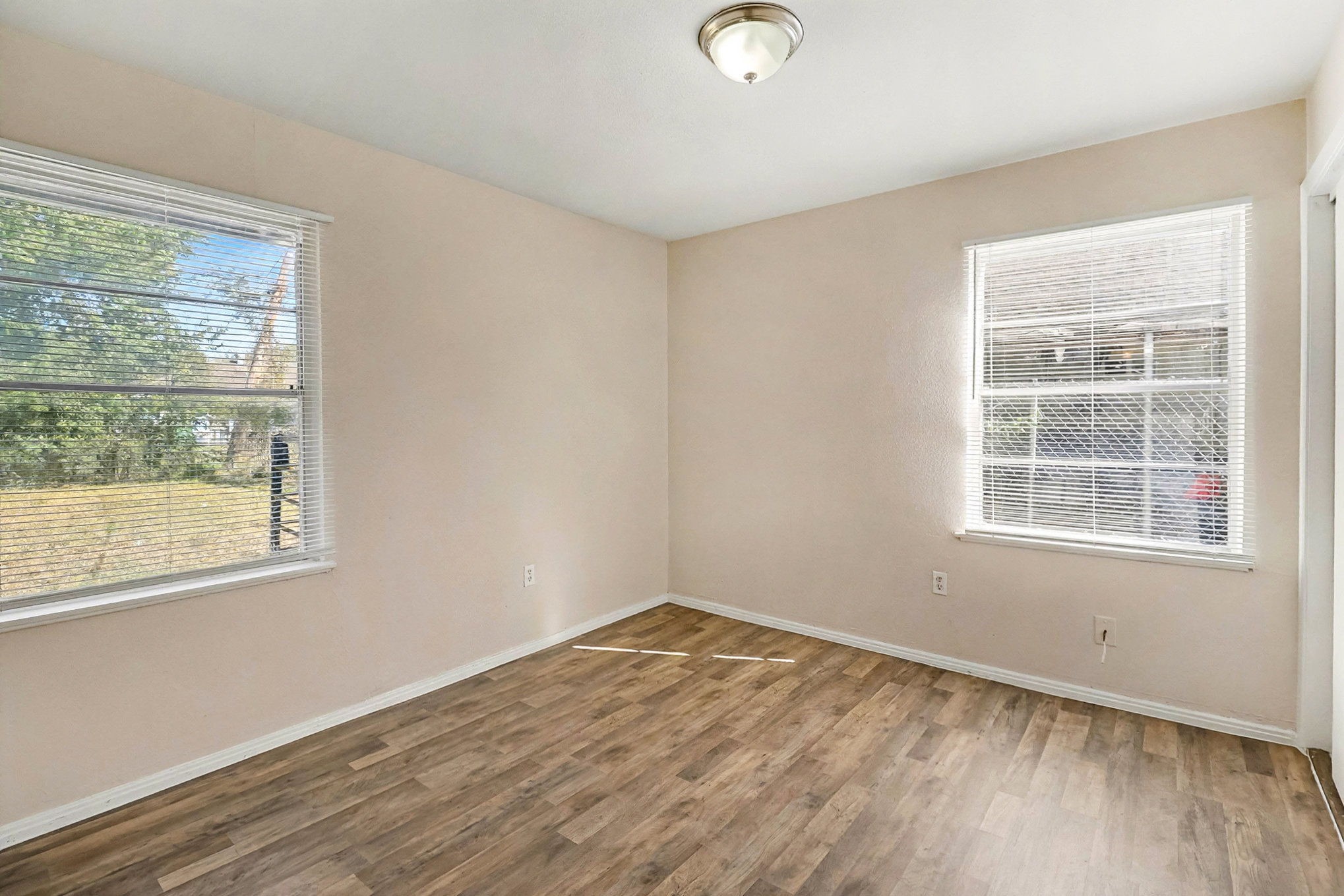 5711 Ridgeway Drive Houston, TX 77033 - Photo 15 of 29 an empty room with wooden floor and windows