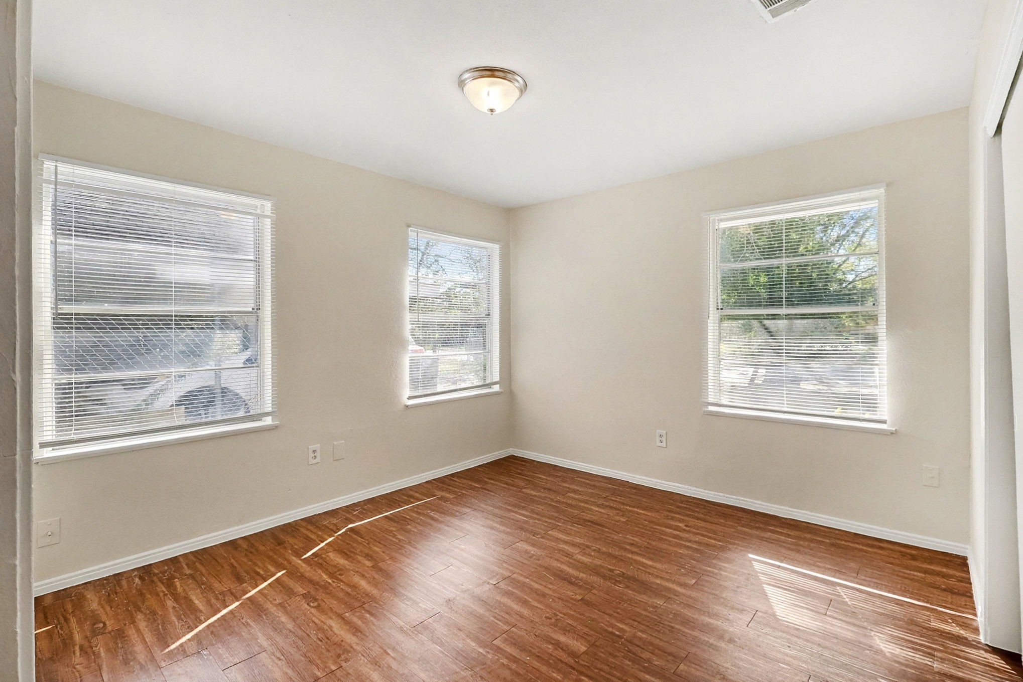 5711 Ridgeway Drive Houston, TX 77033 - Photo 21 of 29 a view of an empty room with wooden floor and a window