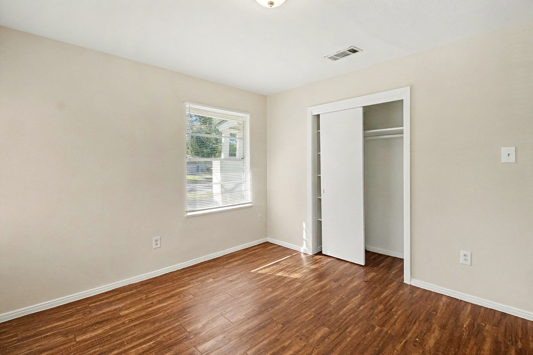 5711 Ridgeway Drive Houston, TX 77033 - Photo 24 of 29 an empty room with wooden floor and windows