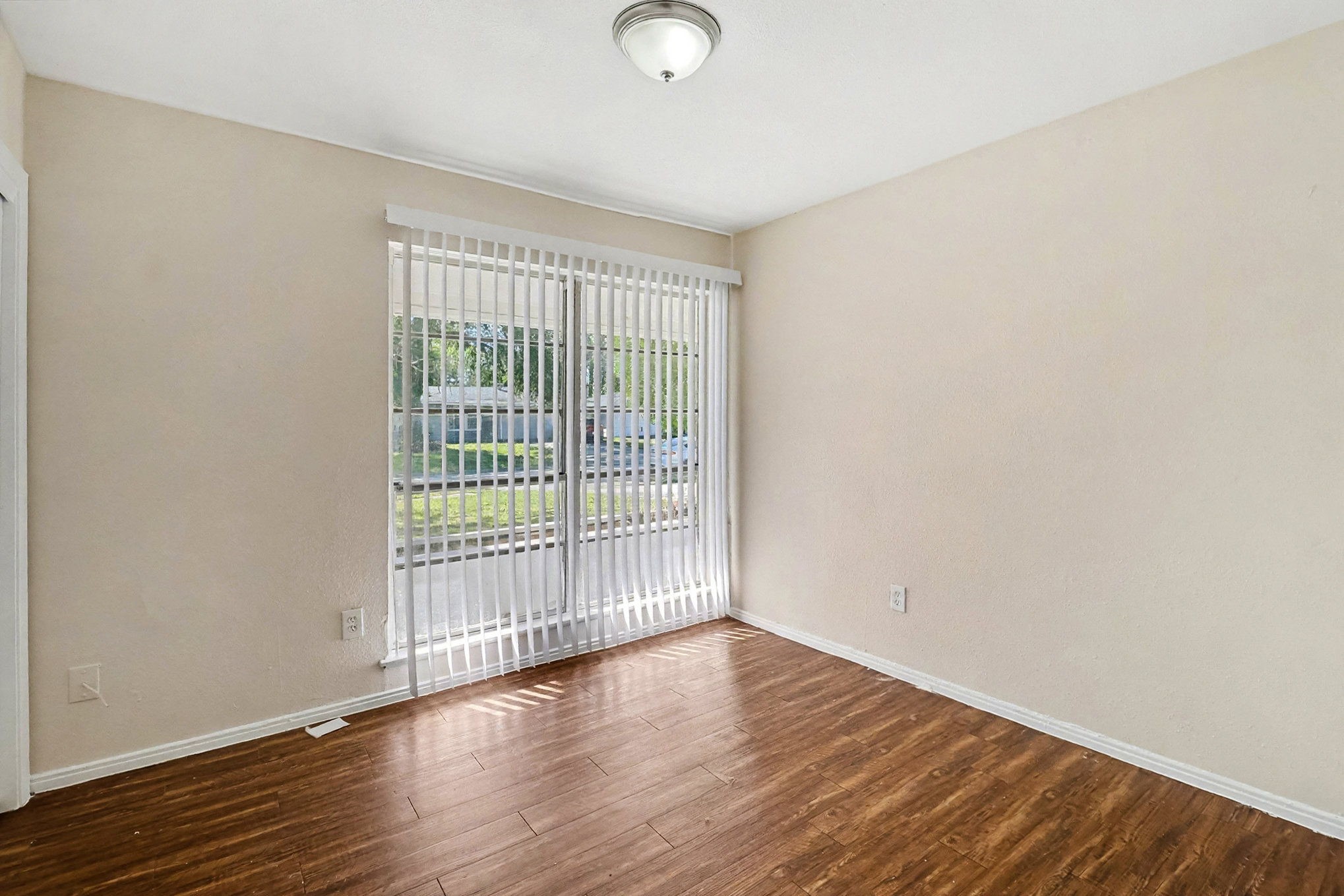 5711 Ridgeway Drive Houston, TX 77033 - Photo 25 of 29 a view of an empty room with wooden floor and a window