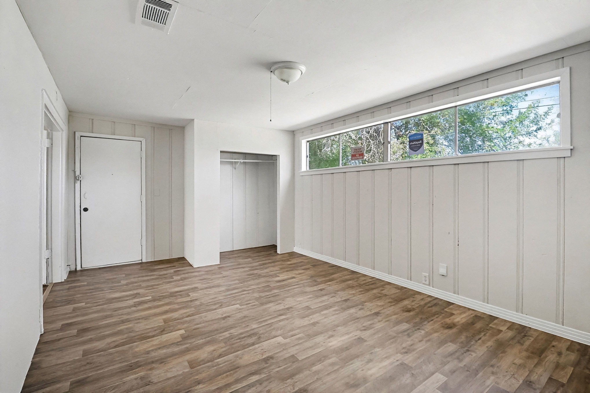 5711 Ridgeway Drive Houston, TX 77033 - Photo 10 of 29 a view of an empty room with wooden floor and a window