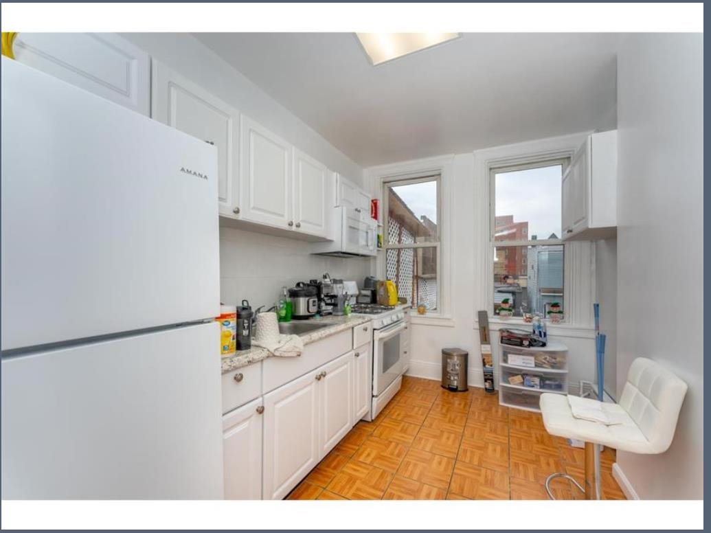 547 57th Street, Unit 2 West New York, NJ 07093 - Photo 2 of 8 a kitchen with stainless steel appliances granite countertop a refrigerator a sink dishwasher and white cabinets with wooden floor
