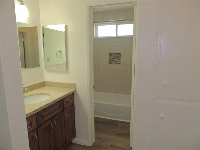 a bathroom with a granite countertop sink and a mirror