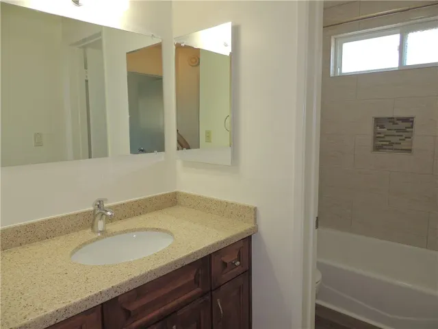 a bathroom with a granite countertop sink and a mirror